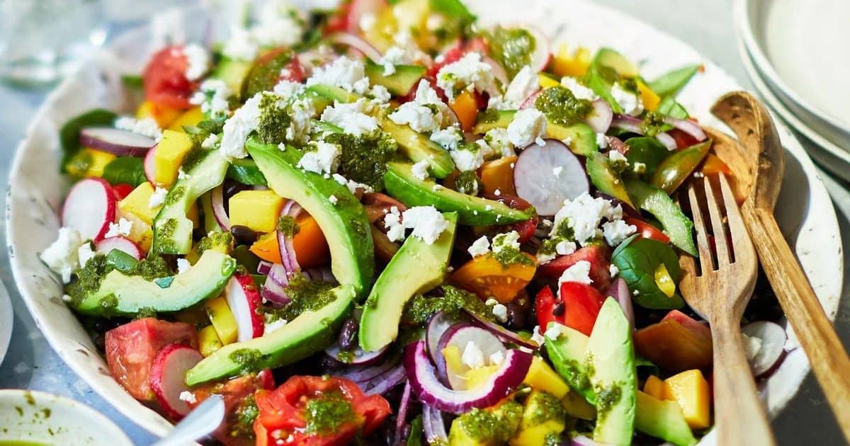 Colorful plant-based summer meal with chickpeas, peaches, and fresh vegetables
